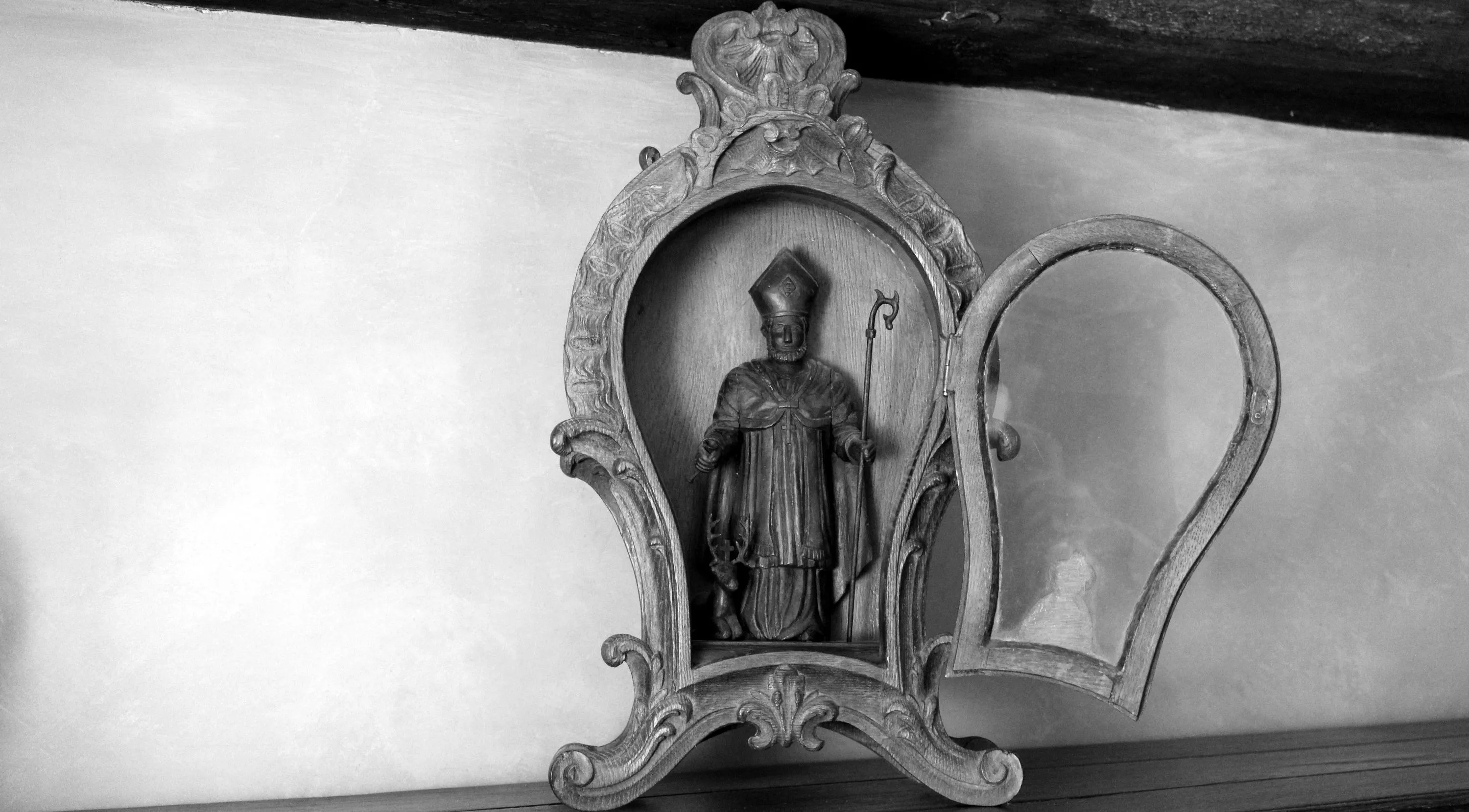 Niche vitrée de forme violonée datant du XIXe siècle, décorée de sculptures de style rocaille, contenant une statue de Saint Hubert accompagnée de son cerf crucifère. Ⓒ 2024 CC BY-NC 4.0 Gilles Pirlot de Corbion
