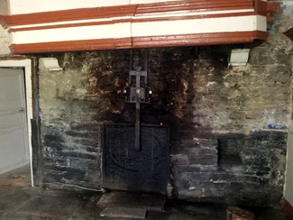 Âtre de la cheminée de la cuisine de la Blanche Maison, avec sa hotte typiquement ardennaise et le crochet de suspension de la crémaillère Ⓒ 2025 CC BY-NC 4.0 Gilles Pirlot de Corbion