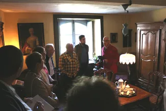 Les invités découvrent la chambre derrière le feu lors de l'inauguration officielle de la Blanche Maison. Ⓒ 2025 CC BY-NC 4.0 Didier Misson Jean-Michel Bodelet, Christiane Collinet, Coralie Bonnet, Jean-Pierre Dardenne, Theo et Sébastien Pierre avec Gilles Pirlot de Corbion dans la chambre derrière le feu