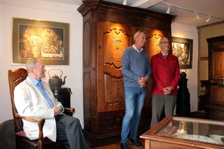 Gérard Lambert regarde Guy Gilloteaux et Gilles Pirlot de Corbion converser devant la majestueuse garde-robe sculptée par Nicolas Mathieu durant le troisième quart du XVIIIe siècle Ⓒ 2025 CC BY-NC 4.0 Didier Misson