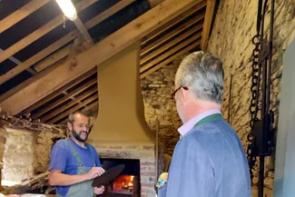 Les quiches ardennaises ont été cuites dans le four à pain de la Blanche Maison. Ⓒ 2025 CC BY-NC 4.0 Didier Misson Hubert de Biolley s'entretient avec Olivier Delforge devant le four à pain de la Blanche Maison