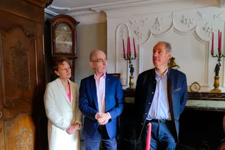 Les invités sont à proximité du trumeau de cheminée en stuc de la belle salle de la Blanche Maison. Ⓒ 2025 CC BY-NC 4.0 Didier Misson Une invitée, Michel Francard et Emmanuel Rogman dans la belle salle de la Blanche Maison