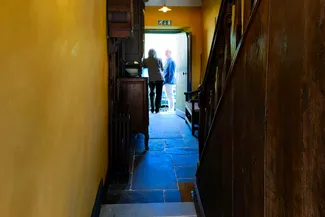 Deux invités échangent quelques mots dans l’embrasure de la porte arrière de la Blanche Maison. Ⓒ 2025 CC BY-NC 4.0 Didier Misson Participants à l'inauguration officielle de la Blanche Maison