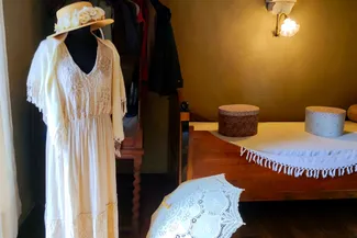 La chambre à la hotte, au-dessus de la cuisine, est celle qui évoque une jeune fille d’antan avec robe en dentelle, châle, ombrelle et chapeau Ⓒ 2025 CC BY-NC 4.0 Didier Misson
