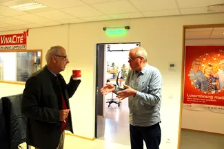 Jean-Marc Decerf décrit à Gilles Pirlot de Corbion le programme de l’heure qui suit devant l’entrée du studio de Vivacité à Libramont