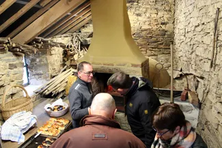 Le four à pain de la Blanche Maison, avec sa typique hotte pyramidale, a permis de cuire au feu de bois les cougnous au chocolat et les cougnous aux raisins selon la tradition culinaire ardennaise.
