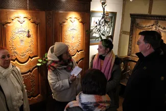 Pauline Foglia, coordinatrice de l'ASBL Qualité-Village-Wallonie pour les provinces de Namur et de Luxembourg, fournit des explications aux participants à propos de la salle Saint-Hubert qui sert de salle d'exposition pour les œuvres d'artistes contemporains.