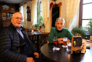 Deux participants au goûter de Noël sont attablés à la taverne Le Rustique à Nisramont.