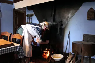 Dans la cuisine de la Blanche Maison, Annie Duterme verse de la pâte dans les fers à oublies
