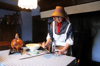 Annie Duterme enduit les fers à oublies avant d'y mettre la pâte