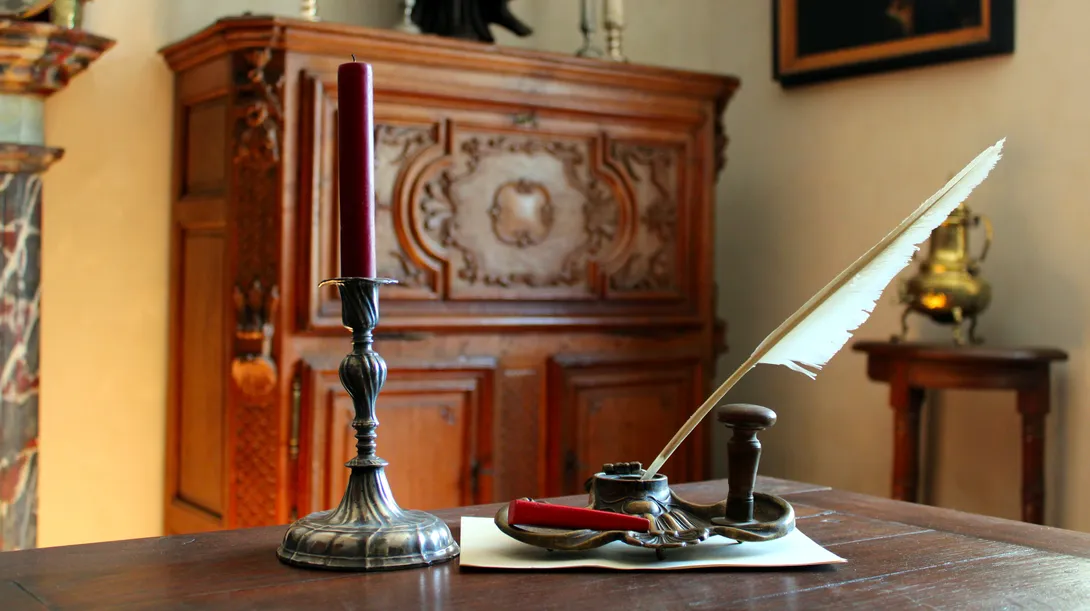Nécessaire de correspondance du XVIIIe siècle composé d'un chandelier torsadé en étain, d'un encrier en bronze de style rocaille muni d'une plume d'oie, d'un bâton de cire à cacheter et d'un cachet en laiton en bois tourné. Ⓒ 2026 CC BY-NC 4.0 Gilles Pirlot de Corbion